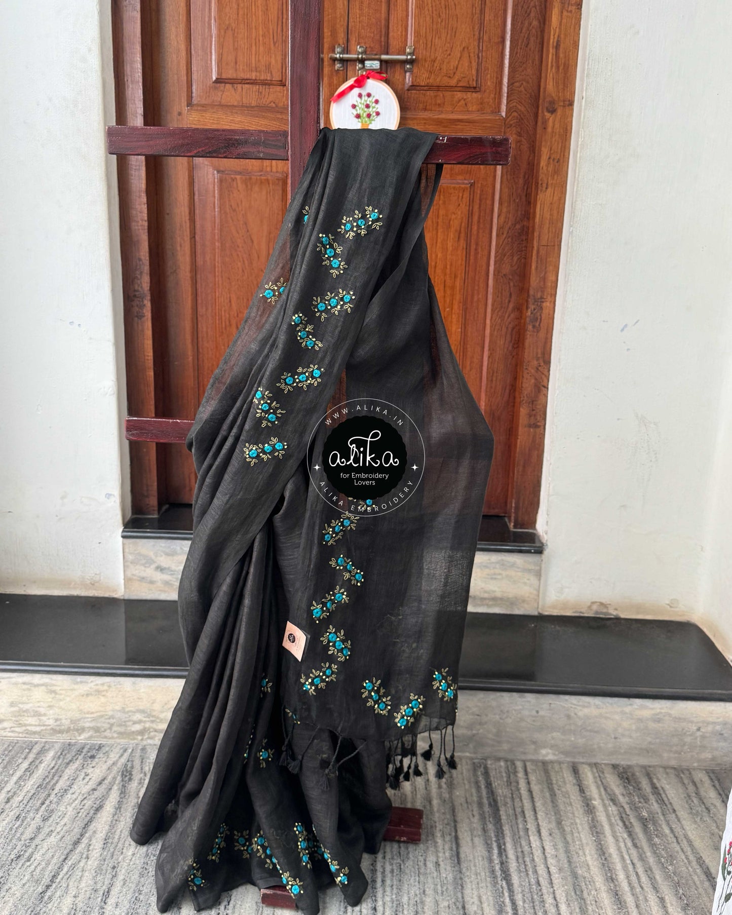 Graceful Black Linen Saree with Vibrant Blue Floral Work